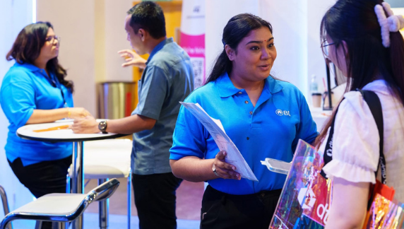 Associados da BD conversando com participantes em um estande de recrutamento.