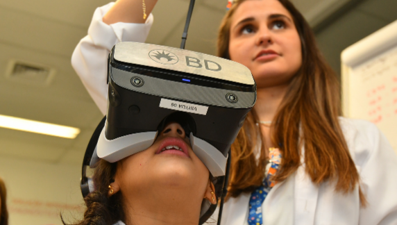 Associado da BD ajudando uma crian&ccedil;a a usar um headset de realidade virtual.