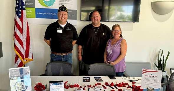 Photo of people at a table smiling with American flag