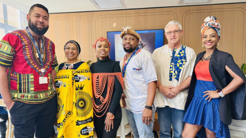Grupo de seis asociados, de pie juntos y sonriendo a la cámara.