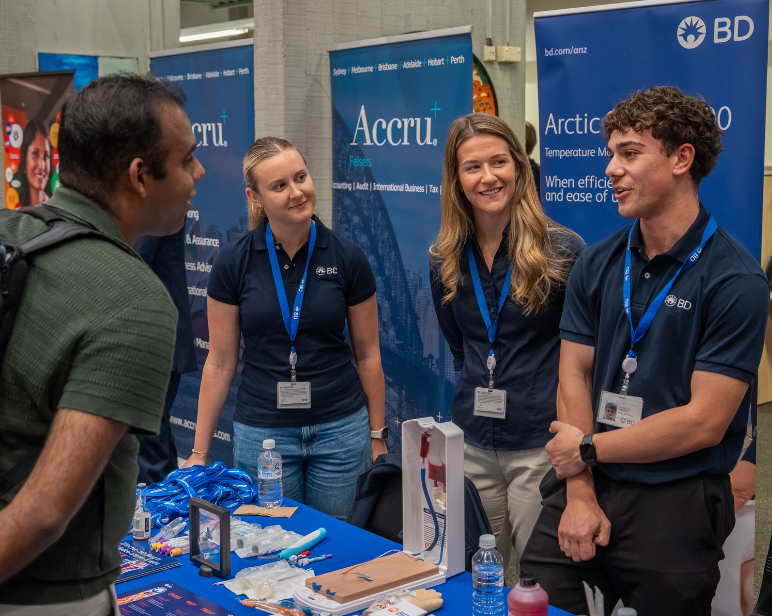 BD associates speaking with attendees at a careers event beside a BD exhibition stand.