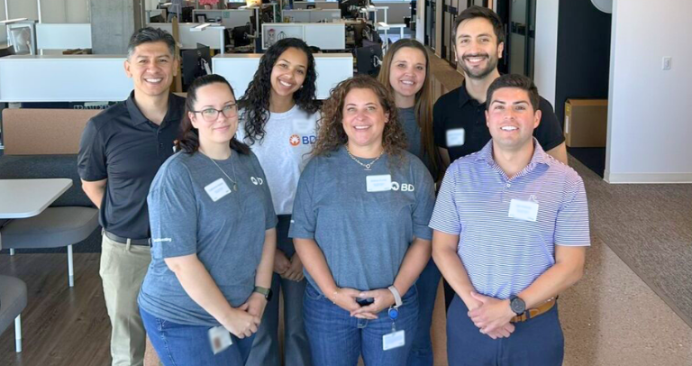 Ocho empleados sonriendo y tomándose una foto