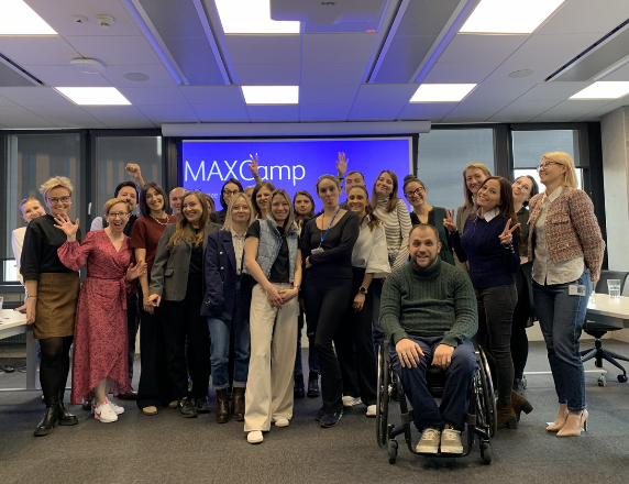 Foto em grupo em um escritório, com todos os funcionários felizes.