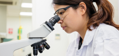 A woman looking into a microscope
