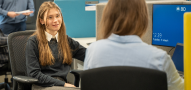 A woman talking to another woman in an office
