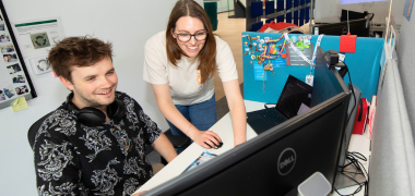 A man and woman looking at a computer screen