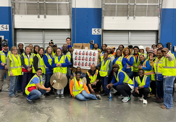 BD associates at volunteering event smiling at camera