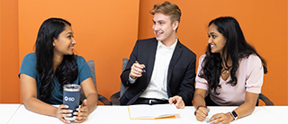 Three employees talking in a meeting room