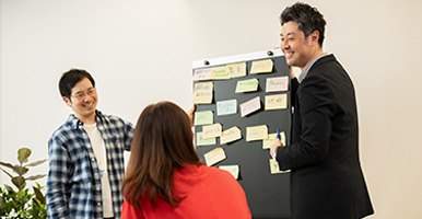 イベント会場にて、3名のBD社員が、BDのロゴと製品が置かれたスタンドの後ろに立っていました