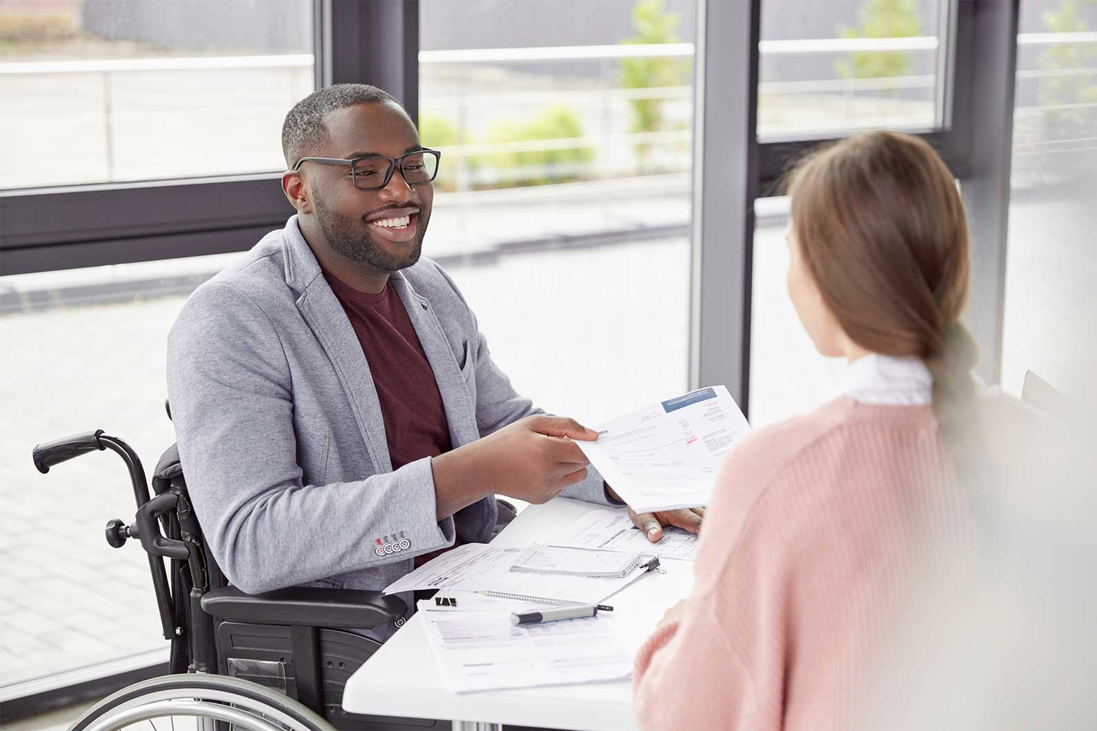 A person on wheelchair speaking to colleague