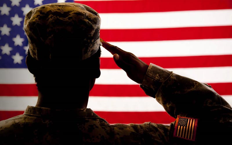 Military solider saluting to the American flag