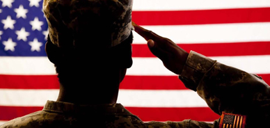 Military solider saluting to the American flag