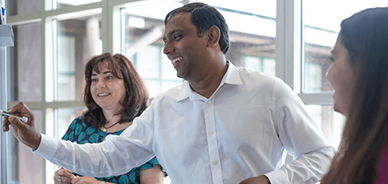 Three people looking at whiteboard