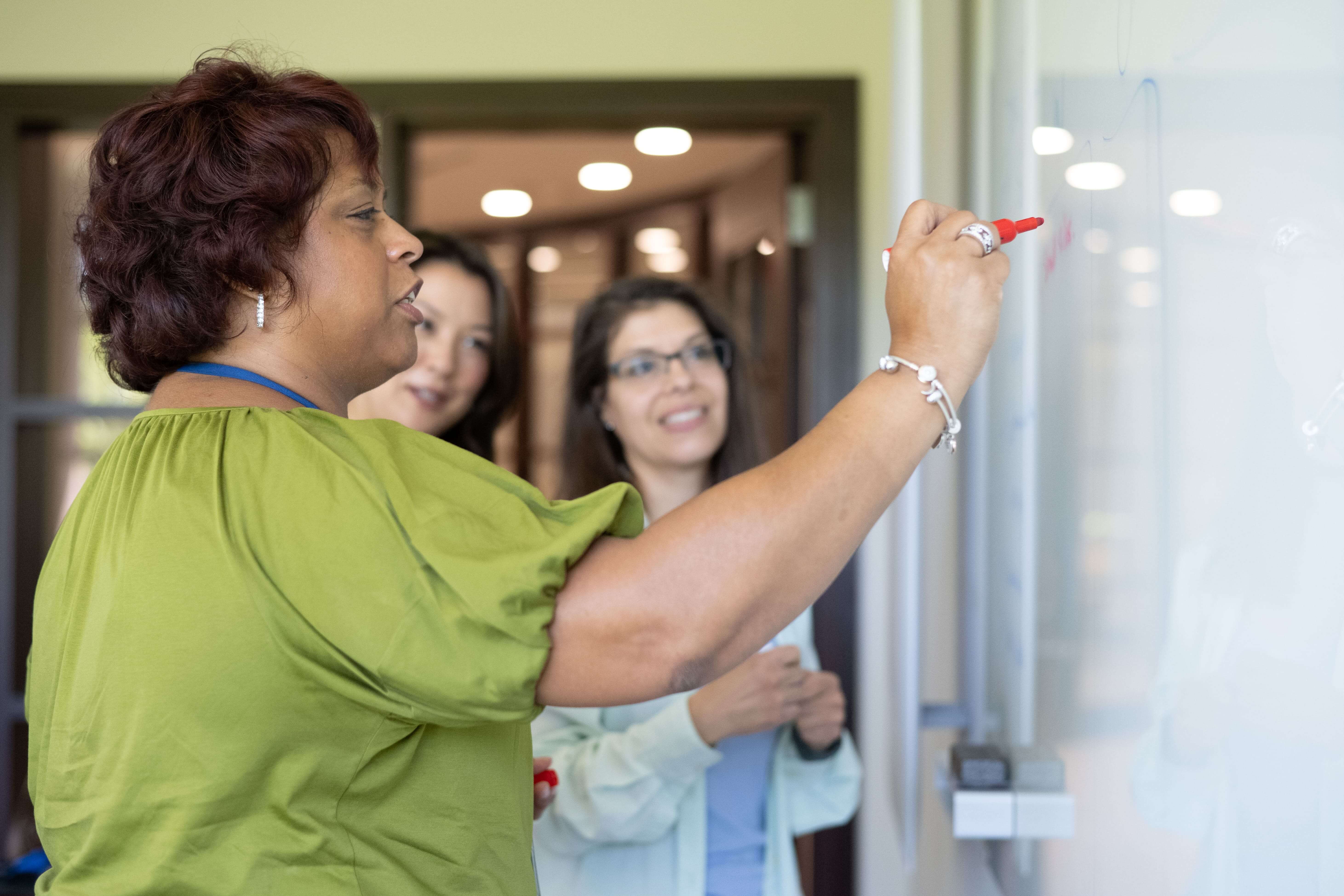 woman presenting ideas on a dry eraseboard