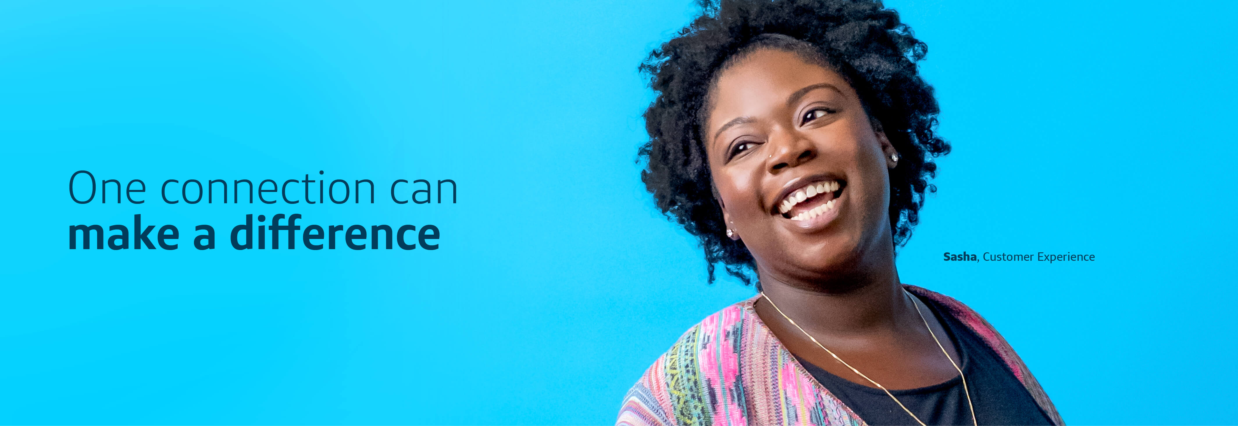 Sasha, a Capital One Customer Experience associate, stands in front of a blue background smiling next to a quote that says, "One connection can make a difference"