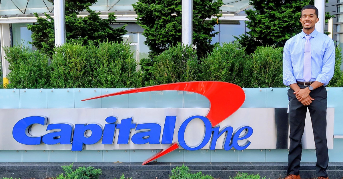 Carlton, a Capital One Tech associate, stands in front of the Capital One sign outside