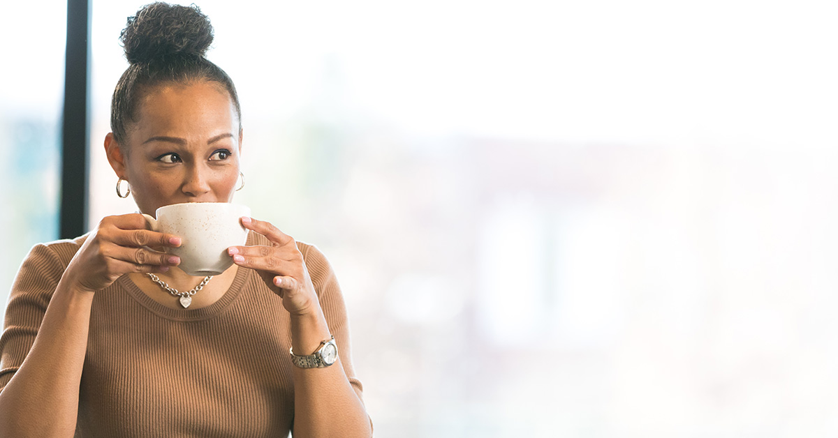 Woman sitting in Capital One sips on her coffee