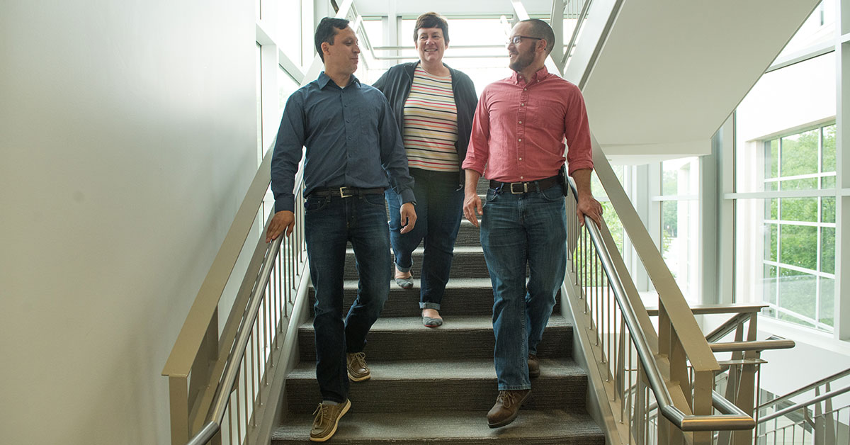 woman discussing diversity of thought on stairs with two men