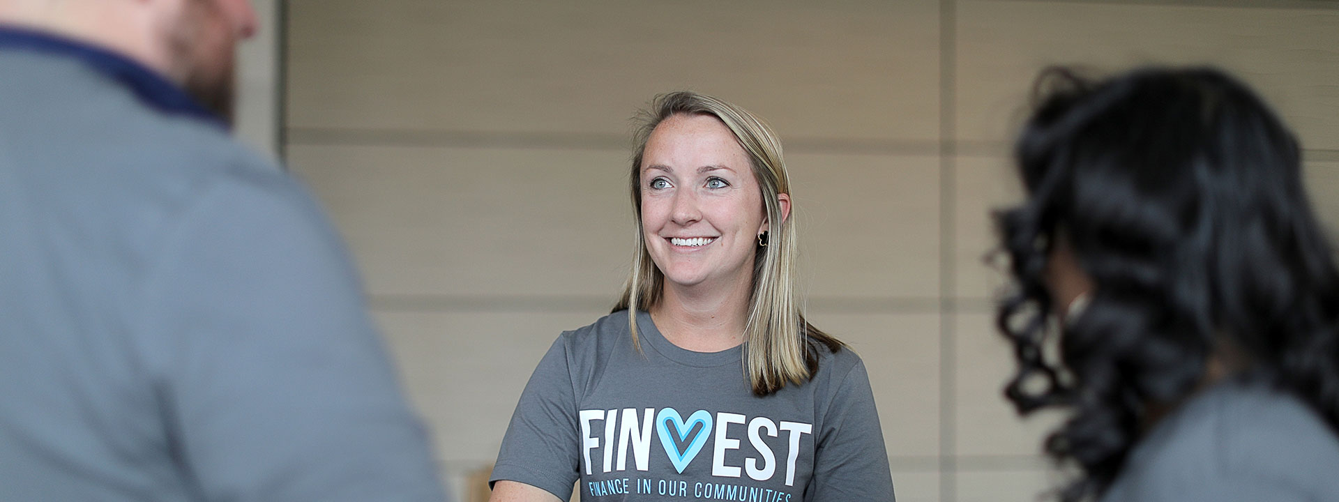 Shannon talking to colleagues while wearing a FINVEST shirt