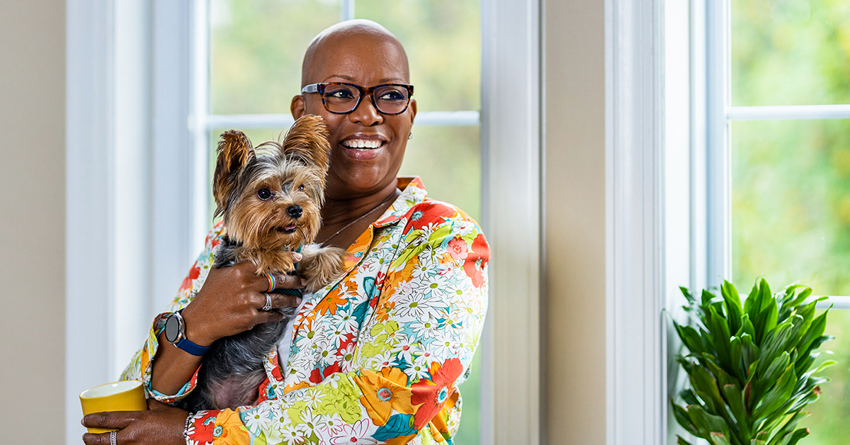 Capital One associate Michelle sits at home holding her dog