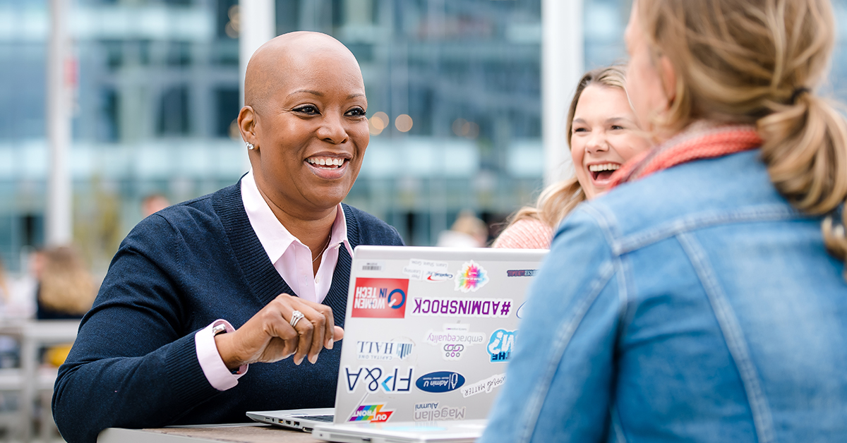 Capital One associate sits at her laptop talking to other associates