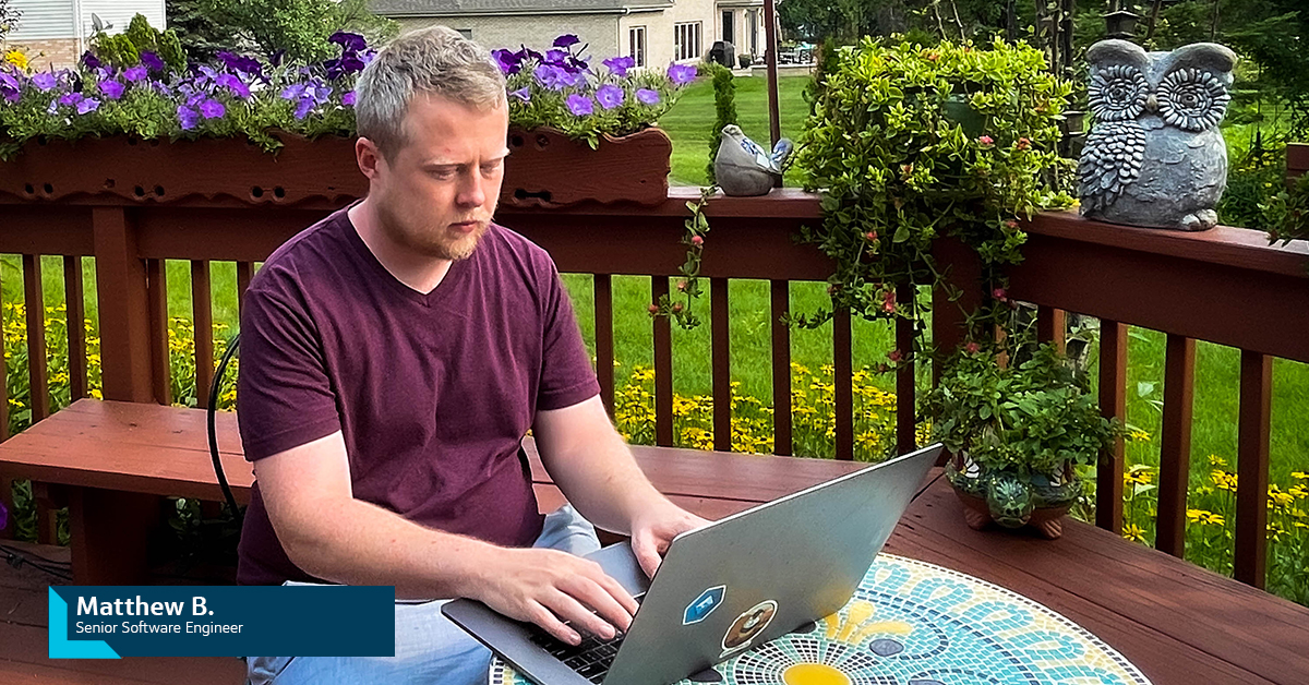 Capital One associate sits on his back porch working on his laptop outside 