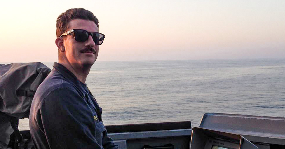Now Capital One veteran associate stands on a ship while out to sea during his military service