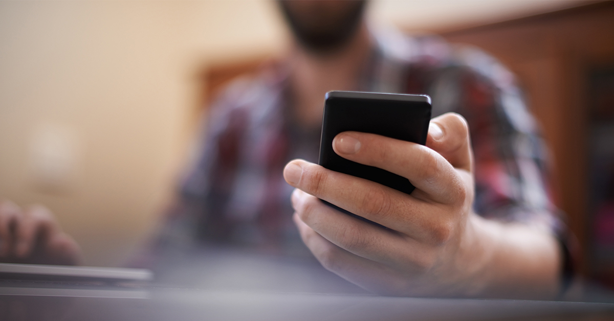 A Capital One associate holds his cell phone