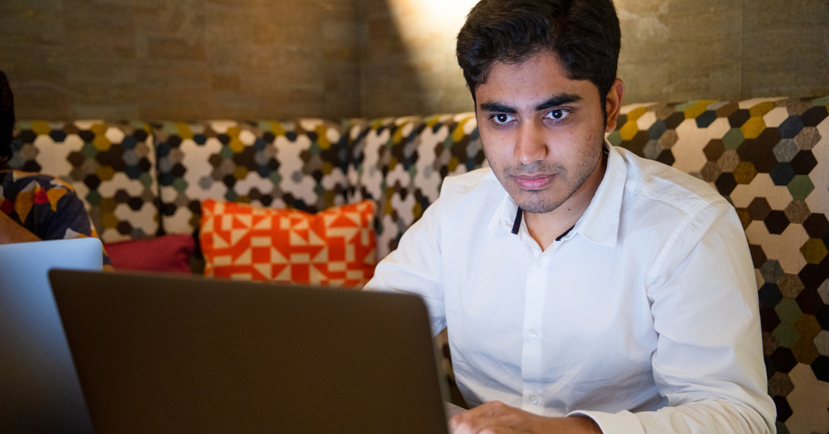 Man sits at laptop and talks about how Capital One associates with hearing difficulties feel more empowered to fully engage with virtual meetings with accessibility changes