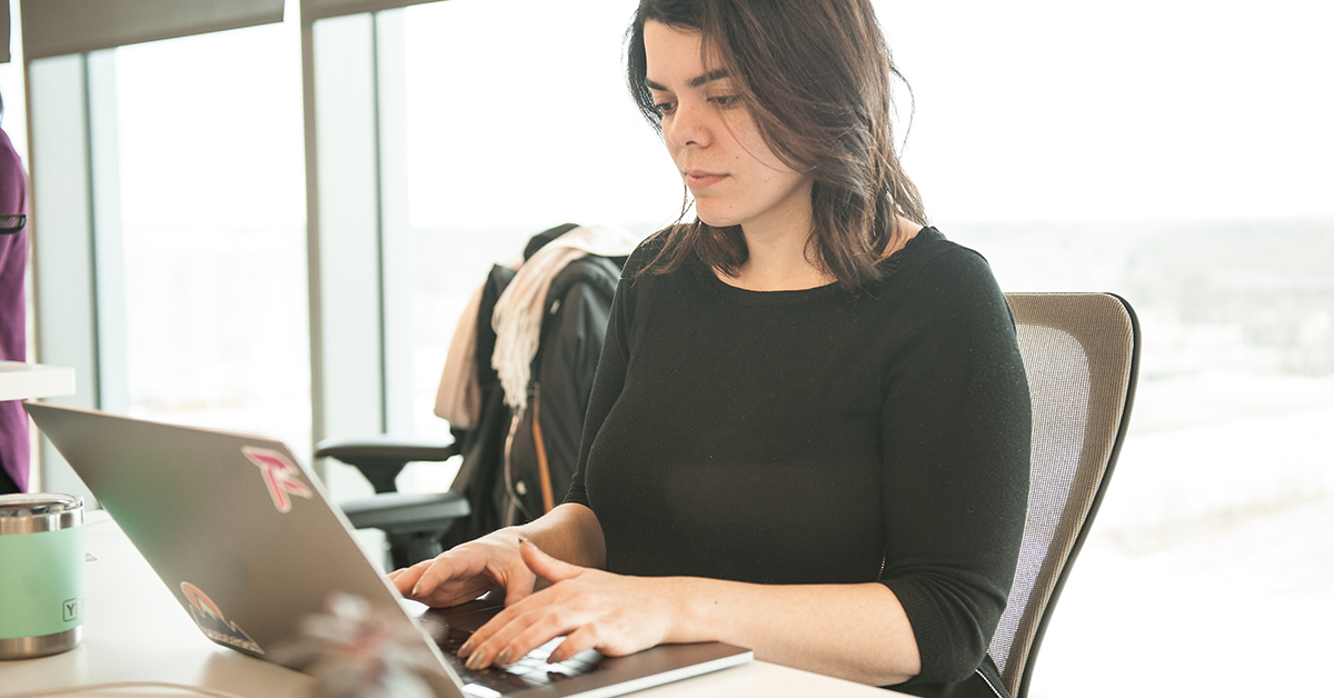 Woman sits at laptop and talks about how Capital One associates with hearing difficulties feel more empowered to fully engage with virtual meetings with accessibility changes