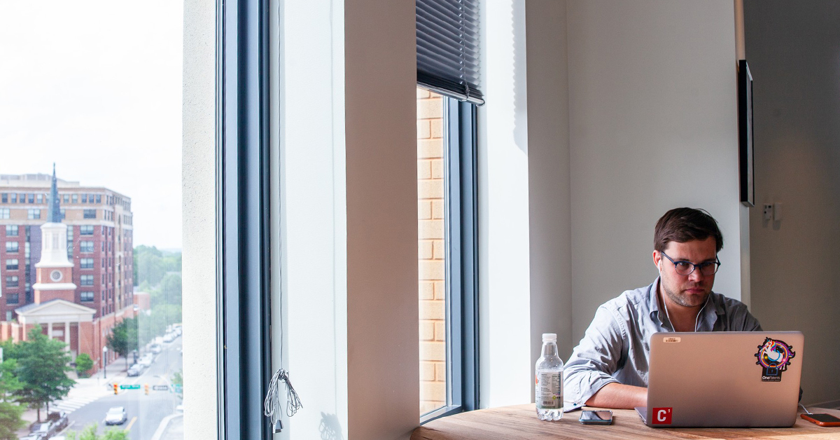 Man sits at laptop and talks about how Capital One associates with hearing difficulties feel more empowered to fully engage with virtual meetings with accessibility changes