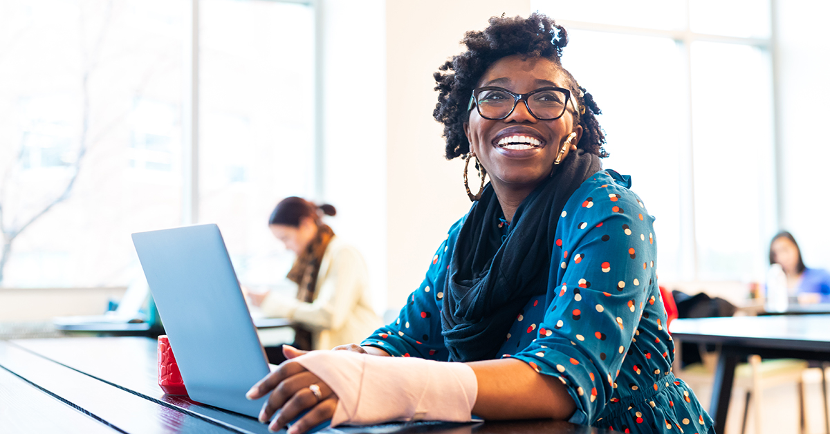 Capital One Tech associate sits at her laptop and laughs