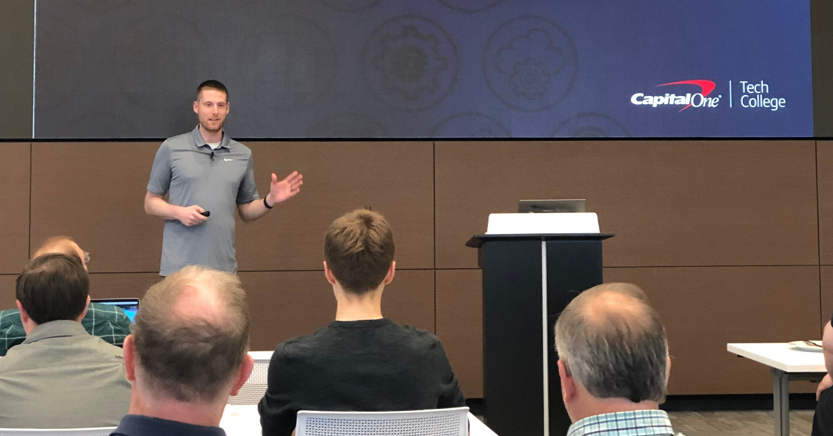 Jared, Capital One tech associate, standing in front of a large screen presenting to Capital One