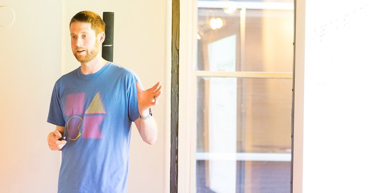 Jared, Capital One tech associate, stands and resents at a Tech workshop