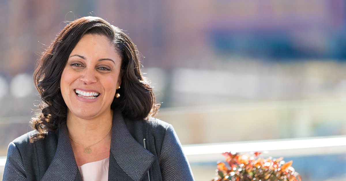 Capital One associate stands outside and smiles, talking about the VOICES Black Business Resource Group