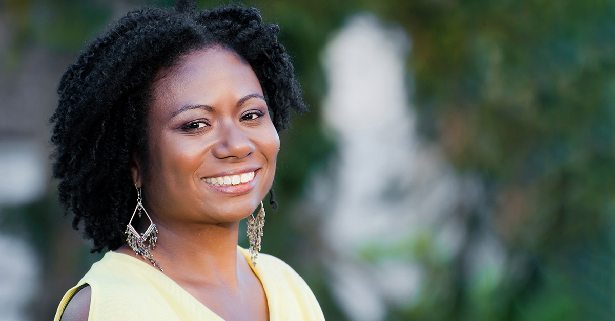 Jamillah, a director at Capital One, stands in front of a green background