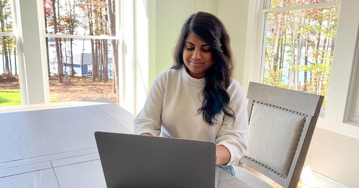 Capital One associate sits at her dining room table on a laptop and talks about the First Gen program