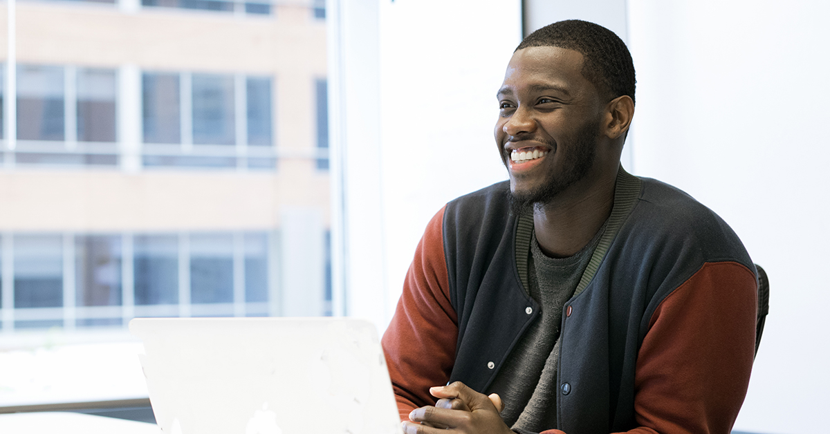 Man at computer maintaining a positive attitude while job searching at Capital One