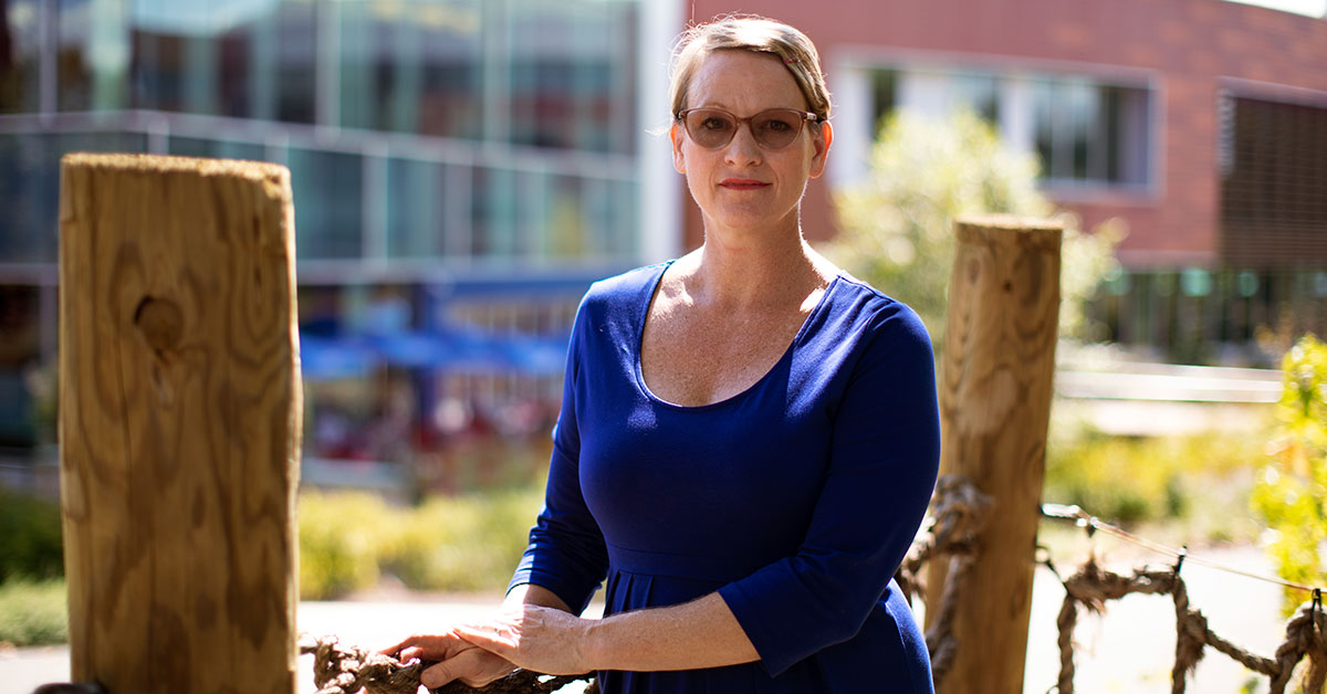 woman standing in a treehouse outside an office building