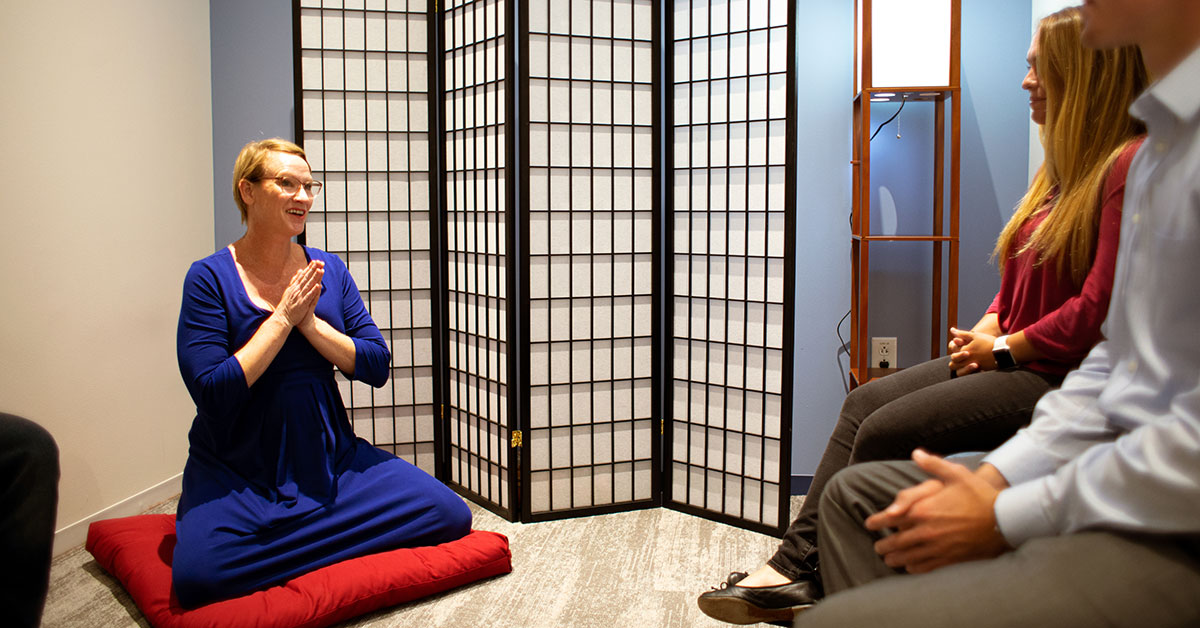 woman leading a meditation session at work