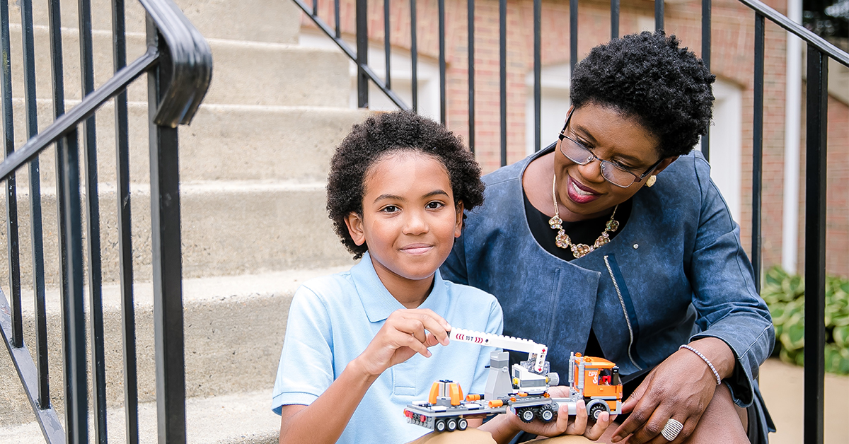 Capital One HR Tech leader Maureen Jules-Perez sits outside with her son and shares her thoughts on Diversity