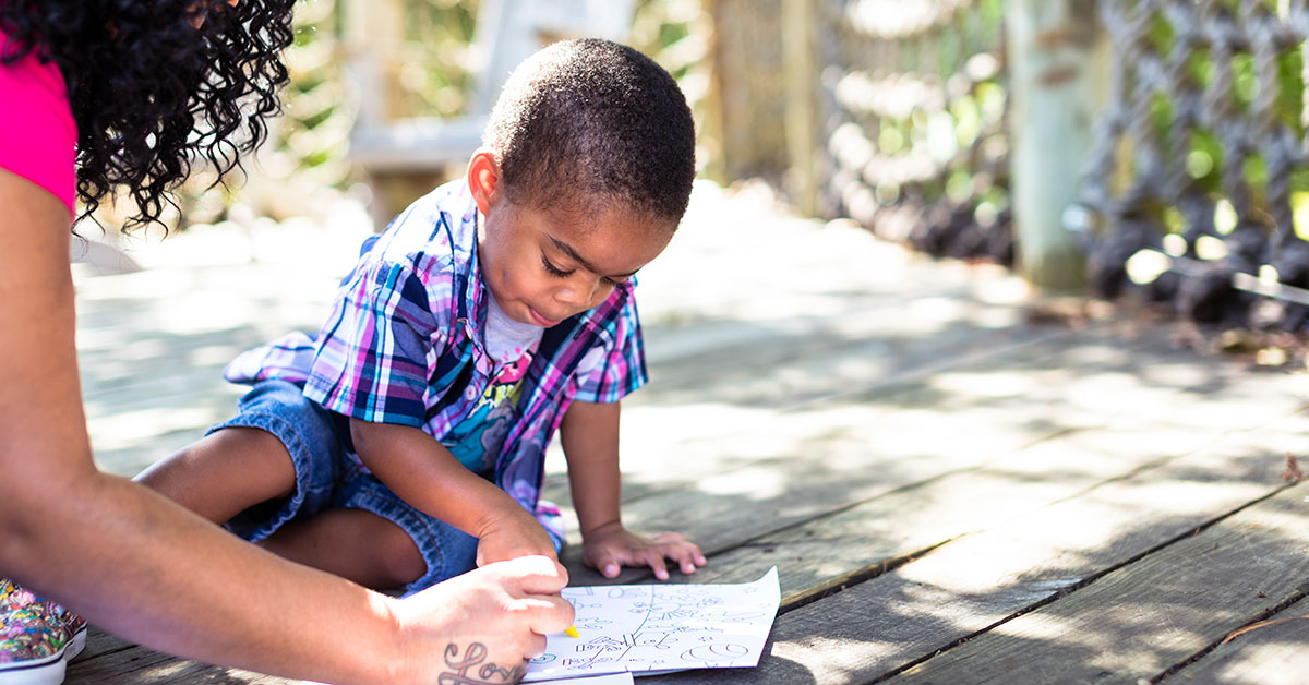 mother working with a son on a coloring book