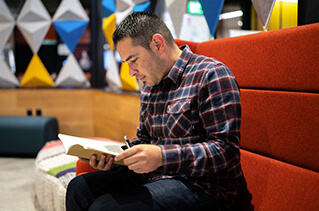 Employee reading a book in an open common area.