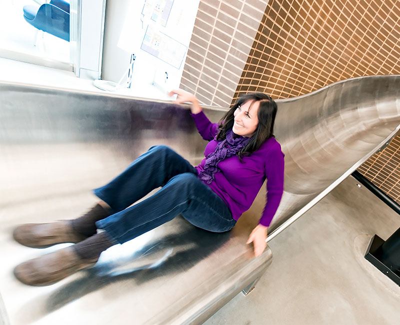 Woman in motion, going down a slide