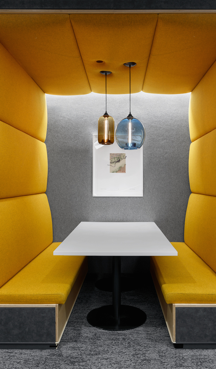 Empty booth and table surrounded floor-to-ceiling with yellow padding