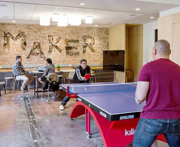 Office space with employees playing table tennis
