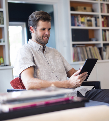 Man working at home on handheld tablet