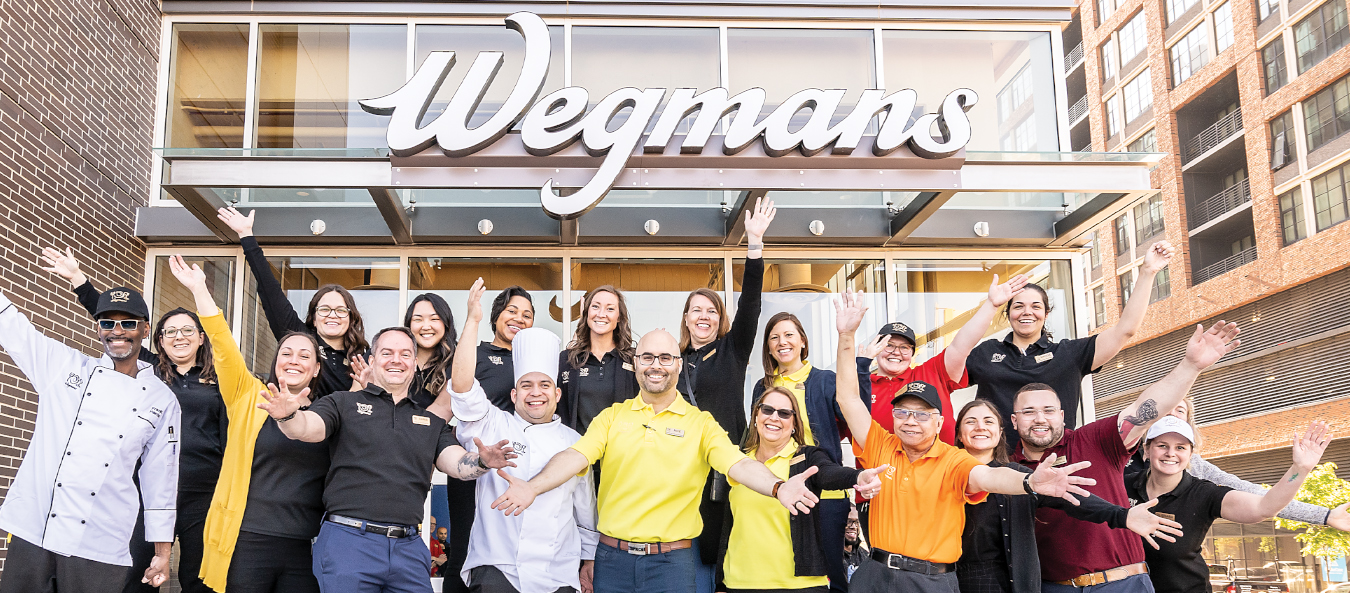 Wegmans employees in front of Wegmans storefront