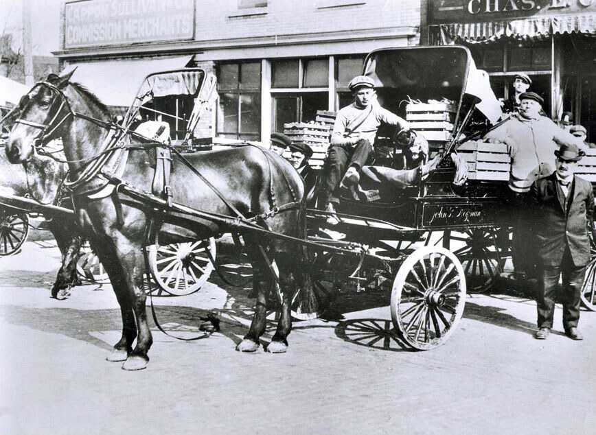 People standing in front of a horse-drawn cart.