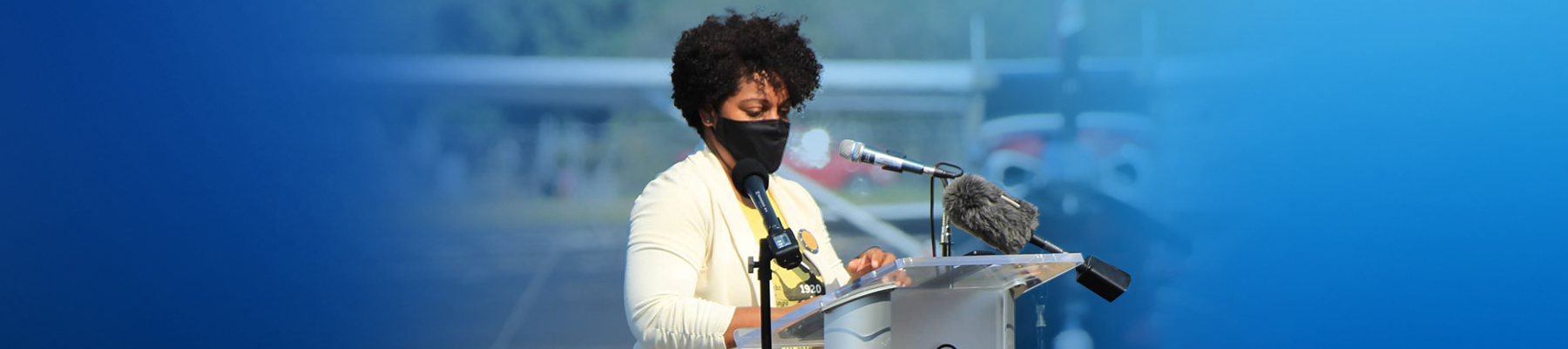 Image of Aurelina wearing a facemask and speaking into a microphone
